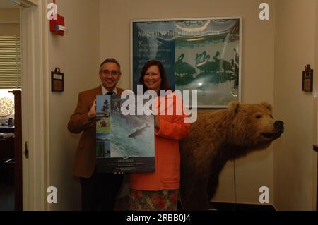 Dru Pearce, Senior Advisor del Segretario per gli affari dell'Alaska, e collega con poster della Rocky Mountain Elk Foundation ringraziando Pearce per il suo lavoro a nome del Perenosa Bay Project su Afognak Island, Alaska. Afognak, le cui popolazioni di pesci e fauna selvatica della costa settentrionale sono state danneggiate a causa della fuoriuscita di petrolio della Exxon Valdez nel 1989, è stata al centro degli sforzi di conservazione e recupero intrapresi dagli Stati Uniti Fish and Wildlife Service in collaborazione con lo stato dell'Alaska e organizzazioni no-profit. Foto Stock