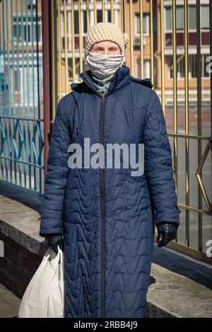 Una povera donna anziana indossa una maschera casalinga per proteggersi da virus come il coronavirus, noto anche come covid-19, o SARS e MERS. È in un Foto Stock