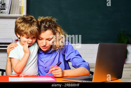 Matematica per bambini. Bambino che studia, fa i compiti con la madre. Insegnante donna che dà lezioni private a un bambino a casa. Insegnante donna che aiuta Foto Stock