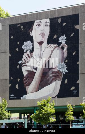 Murale, la donna è abbracciata da mani di colori diversi e infilata da fiori, murale della graffitista Tamara Alves, Street art, Porto, Portogallo Foto Stock