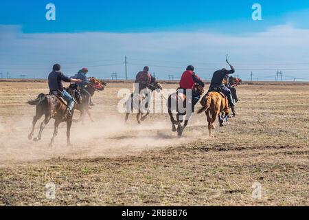 Uomini che praticano il Kokpar, gioco nazionale di cavalli, Kazakistan Foto Stock