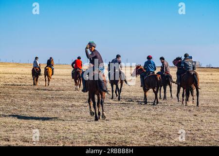 Uomini che praticano il Kokpar, gioco nazionale di cavalli, Kazakistan Foto Stock