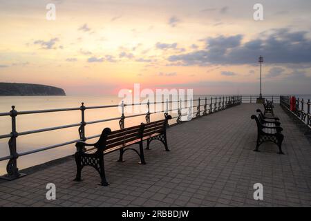 Swanage, Dorset, Regno Unito. 8 luglio 2023. Meteo del Regno Unito: I bellissimi colori dell'alba illuminano il cielo all'alba, mentre il fronte meteorologico porta il clima mutevole nella località balneare di Swanage il sabato mattina. Crediti: Celia McMahon/Alamy Live News Foto Stock