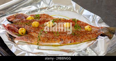 Pesce tradizionale di acciuga (Pomatomus saltador) stagionato pronto per essere cotto in forno Foto Stock
