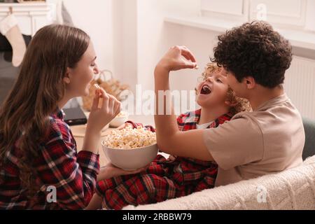 La famiglia passa del tempo insieme a casa. Mangiare popcorn Foto Stock