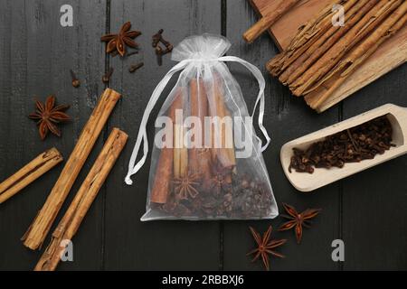 Sacchetto profumato con bastoncini di cannella e stelle di anice su un tavolo di legno, piatto Foto Stock