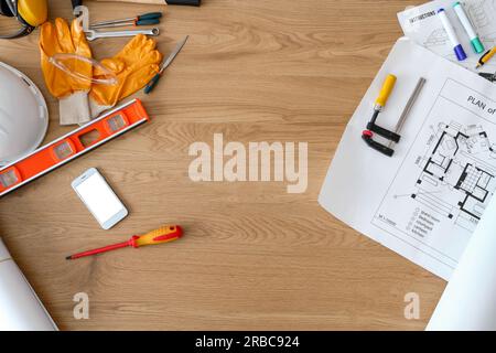Telaio realizzato con forniture per l'edilizia con telefono cellulare su tavolo in legno, vista dall'alto Foto Stock