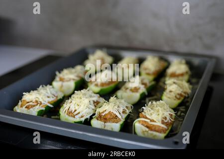 Zucchine crude ripiene di carne macinata preparate per la cottura Foto Stock