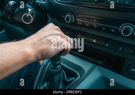 primo piano della mano di un uomo, un uomo tiene la mano sulla leva del cambio nella macchina c'è un posto per un'iscrizione. Foto di alta qualità Foto Stock