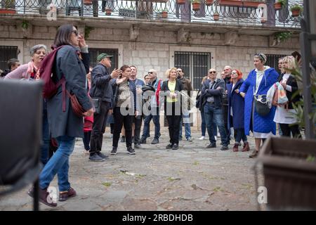 Cattaro, Montenegro, 13 aprile 2023: Un grande gruppo di turisti si è riunito intorno alla guida presso la Piazza del Cinema nella città vecchia Foto Stock