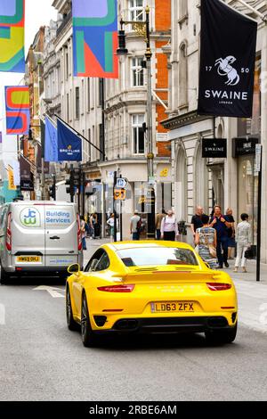 Londra, Inghilterra, Regno Unito - 27 giugno 2023: Vista posteriore di una Porsche Carrera 911 Turbo S gialla che guida lungo New Bond Street nel centro di Londra. Foto Stock