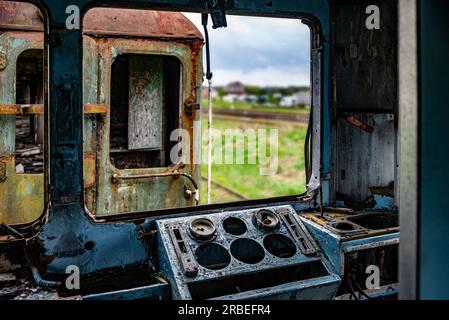 VEW dalla cabina di un vecchio treno elettrico per passeggeri danneggiato - sfondo colorato con attenzione selettiva al banco strumenti del conducente Foto Stock