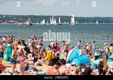 Danzica, Polonia. 9 luglio 2023. Gente che si avvicina al molo e alla spiaggia di Brzezno nella baia di Danzica godendosi la parata delle navi del festival marittimo Baltic Sail. La città di Danzica ospita per la 27esima volta il festival della vela Baltic Sail con partecipanti provenienti da tutti i paesi vicini al Mar Baltico. Il rally è tradizionalmente aperto a tutte le imbarcazioni, inclusi yacht turistici, taglierini e motoscafi. Il programma principale dell'evento per la domenica si svolge tradizionalmente nella baia di Danzica, per consentire a migliaia di visitatori, turisti e locali di godersi l'evento. Crediti: Ognyan Yosifov/Alamy Live News Foto Stock