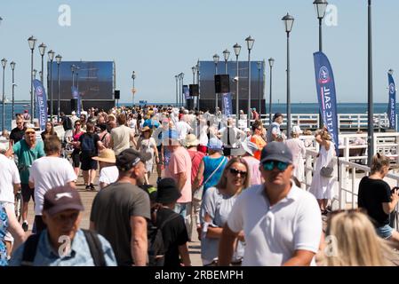 Danzica, Polonia. 9 luglio 2023. Persone al molo e alla spiaggia di Brzezno nella baia di Danzica in attesa della parata delle navi del festival marittimo Baltic Sail. La città di Danzica ospita per la 27esima volta il festival della vela Baltic Sail con partecipanti provenienti da tutti i paesi vicini al Mar Baltico. Il rally è tradizionalmente aperto a tutte le imbarcazioni, inclusi yacht turistici, taglierini e motoscafi. Il programma principale dell'evento per la domenica si svolge tradizionalmente nella baia di Danzica, per consentire a migliaia di visitatori, turisti e locali di godersi l'evento. Crediti: Ognyan Yosifov/Alamy Live News Foto Stock