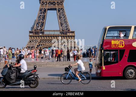 Parigi, Francia - 25 giugno 2023: Veduta dell'affollata piazza del Trocadero, con autobus, bicicletta e moto che passano davanti alla Torre Eiffel a Parigi Foto Stock