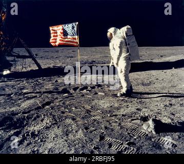 Luna: 20 luglio 1969 l'astronauta Edwin 'Buzz' Aldrin, pilota del modulo lunare, posa accanto alla bandiera degli Stati Uniti durante lo sbarco lunare dell'Apollo 11. Il modulo Lunar "Eagle" è sulla sinistra. Il comandante Neil Armstrong ha scattato la foto. Foto Stock