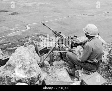 Tuy Hoa, Vietnam: 24 agosto 1966 Un mitragliatore della 101st Airborne Division arroccato sulla cima di una montagna ha una vista dominante della valle sottostante. Foto Stock