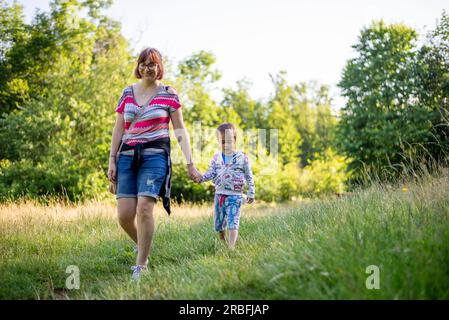 madre e figlio camminano nella natura in estate Foto Stock