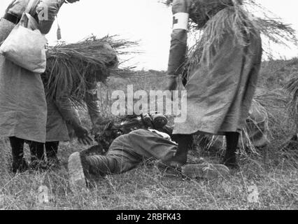 Canton, Cina: circa 1936 donne cinesi mimetizzate soldati che danno aiuto a un soldato ferito. Foto Stock