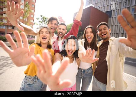Allegri amici di gruppo multiculturali che salutano con piacere la fotocamera. Ritrarre giovani allegri eccitati Foto Stock