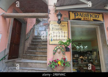 Riomaggiore Italia - aprile 26 2011; porta rustica aperta nel caffè Panificio Rosi accanto a scale di cemento nel villaggio italiano Foto Stock