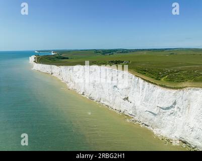 Vista aerea dalle scogliere di gesso di Beachy Head verso le sette Sorelle, il faro di Belle Tout all'orizzonte, South Downs, East Sussex, Inghilterra Foto Stock