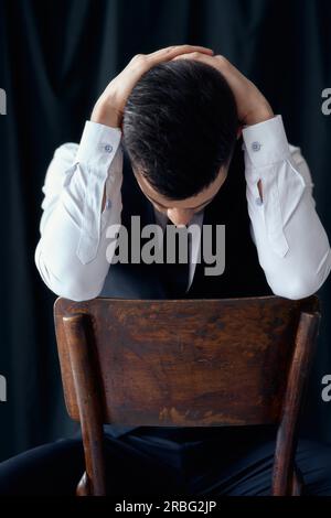 Stanco ed annoiato uomo bello tenendo la testa con le mani. Crisi, concetto di depressione Foto Stock