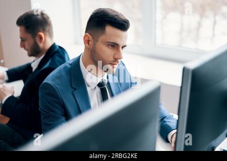 Azienda giovane uomo che lavora sul computer nel suo posto di lavoro. Ufficio concetto di vita Foto Stock