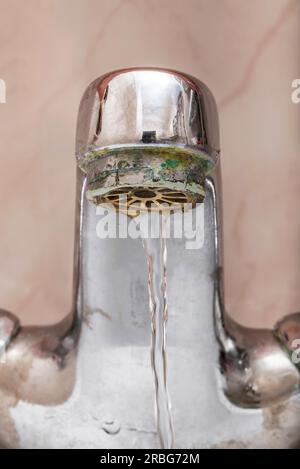 Macro di un rubinetto con acqua che scorre lentamente durante un periodo di penuria Foto Stock