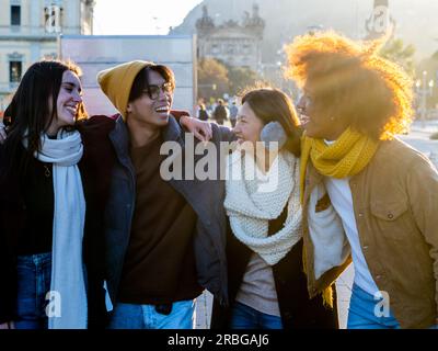Gruppo di amici multietnici in abiti invernali che si divertono in una città. Concetto di comunità, amicizia, inverno Foto Stock