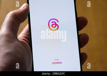 Mano dell'uomo che tiene in mano uno smartphone che mostra l'app Instagram Threads di Meta su uno sfondo bianco con spazio per la copia. REGNO UNITO Foto Stock