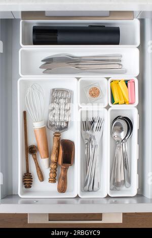 Vassoi Organizer con un set di posate in un cassetto in cucina. Concetto di sistema di storage. Foto Stock