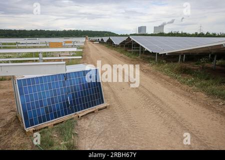 5 luglio 2023, Sassonia, Neukieritzsch: I lavoratori assemblano pannelli solari sul sito del parco energetico di Witznitz. Una gigantesca centrale solare sta crescendo su 500 ettari di terreno nella discarica dell'ex miniera di lignite a cielo aperto Witznitz II nel sud di Lipsia. Circa il 15% dei circa 1,1 milioni di moduli fotovoltaici provenienti dalla Cina sono già stati installati e il parco solare dovrebbe essere online in autunno. Con una capacità installata di 650 megawatt, il parco ha un terzo della produzione della vicina centrale elettrica alimentata a lignite di Lippendorf (due unità con 920 me Foto Stock