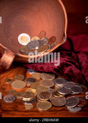 I soldi di diversi paesi sono combinati in una ciotola di argilla Foto Stock