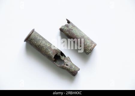 vecchie cartucce militari sepolte nel terreno su uno sfondo bianco, cartucce del secondo mondo puzzolenti da vicino, proiettili Foto Stock