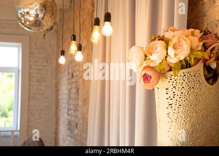 bouquet con fiori vicino alle lampade sulla parete in stile retrò per lo sfondo, decor nell'appartamento, sfondo interno Foto Stock