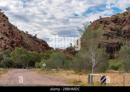 La strada di ingresso sterrata per Emily Gap (Yeperenye), parte della catena montuosa East MacDonnell (Tjoritja) vicino ad Alice Springs (Mparntwe) nell'Australia centrale Foto Stock