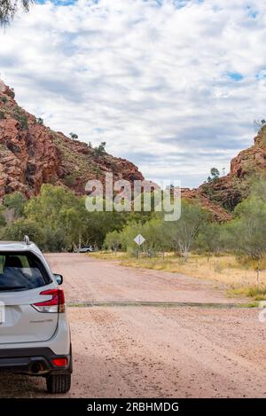 La strada di ingresso sterrata per Emily Gap (Yeperenye), parte della catena montuosa East MacDonnell (Tjoritja) vicino ad Alice Springs (Mparntwe) nell'Australia centrale Foto Stock