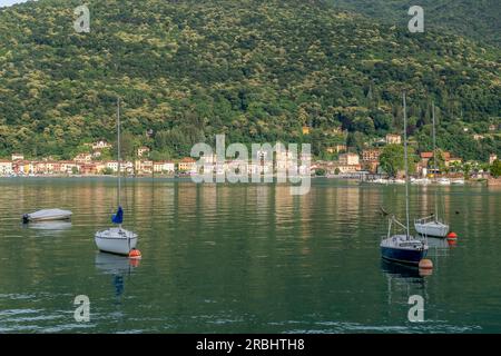 Barche ancorate sul Lago di Lugano, con Porto Ceresio sullo sfondo, Italia Foto Stock