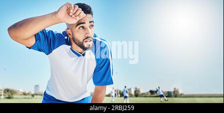 Giocatore di calcio, stanco e uomo che suda all'aperto su un campo per sport e gare di fitness. Un atleta o un calciatore di sesso maschile in pausa Foto Stock