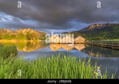 Capanne nautiche sul Kochelsee di fronte a Jochberg (1.565 m) e Herzogstand (1.731 m), Schlehdorf, alta Baviera, Baviera, Germania Foto Stock