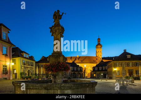 Statua presso la fontana e la torre illuminata del castello di Weikersheim al crepuscolo, Weikersheim, Franconia, Baden-Wuerttemberg, Germania, Europa Foto Stock