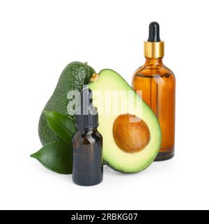 Bottiglie di olio essenziale e avocado fresco su fondo bianco Foto Stock