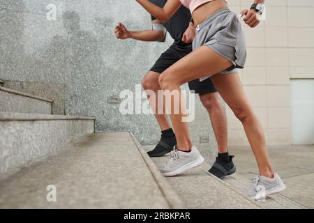 Immagine ritagliata della coppia attiva che sale le scale Foto Stock