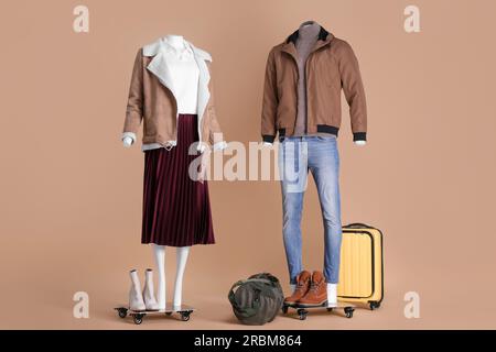 Manichini femminili e maschili con accessori vestiti in abiti diversi su sfondo beige. Outfit eleganti Foto Stock