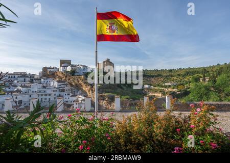 Bandiera di Spagna e skyline di Setenil de las Bodegas - Setenil de las Bodegas, Andalusia, Spagna Foto Stock