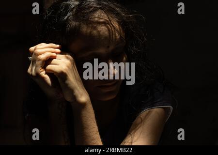 Bellissimo ritratto di donna indiana con ombre e luci. Suggestivo ritratto di donna indiana con ombre e luci sul viso. Primo piano delle patatine del corpo Foto Stock