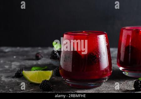 Berry Lemonade, bevanda rinfrescante, cocktail, tè freddo, BlackBerry e Lime Summer drink su sfondo scuro Foto Stock