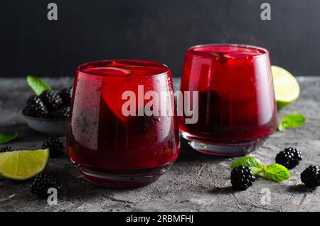 Berry Lemonade, bevanda rinfrescante, cocktail, tè freddo, BlackBerry e Lime Summer drink su sfondo scuro Foto Stock