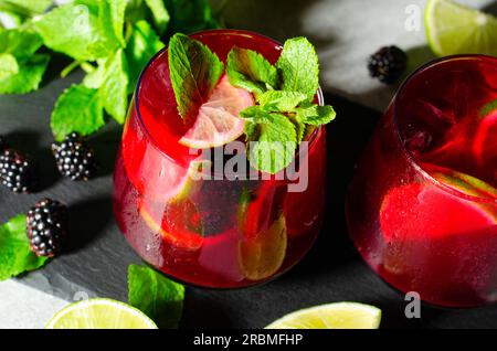 Berry Lemonade, bevanda rinfrescante, cocktail, tè freddo, mora e limone in un ambiente estivo luminoso Foto Stock